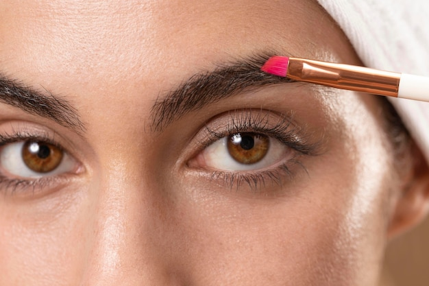 Woman applying eyebrow makeup with a brush