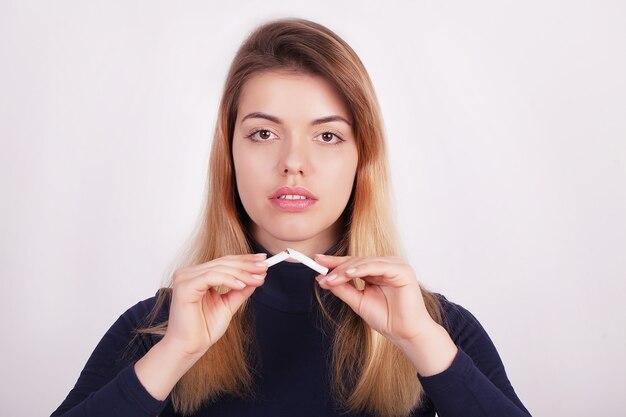 Woman holding a broken cigarette in her hands